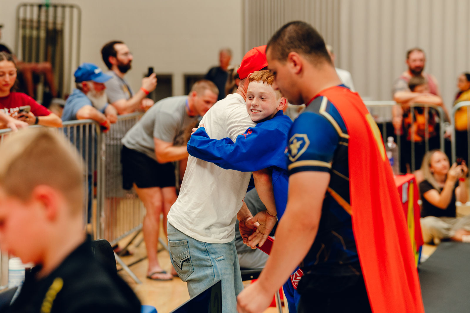 A coach hugging a young athlete after a match
